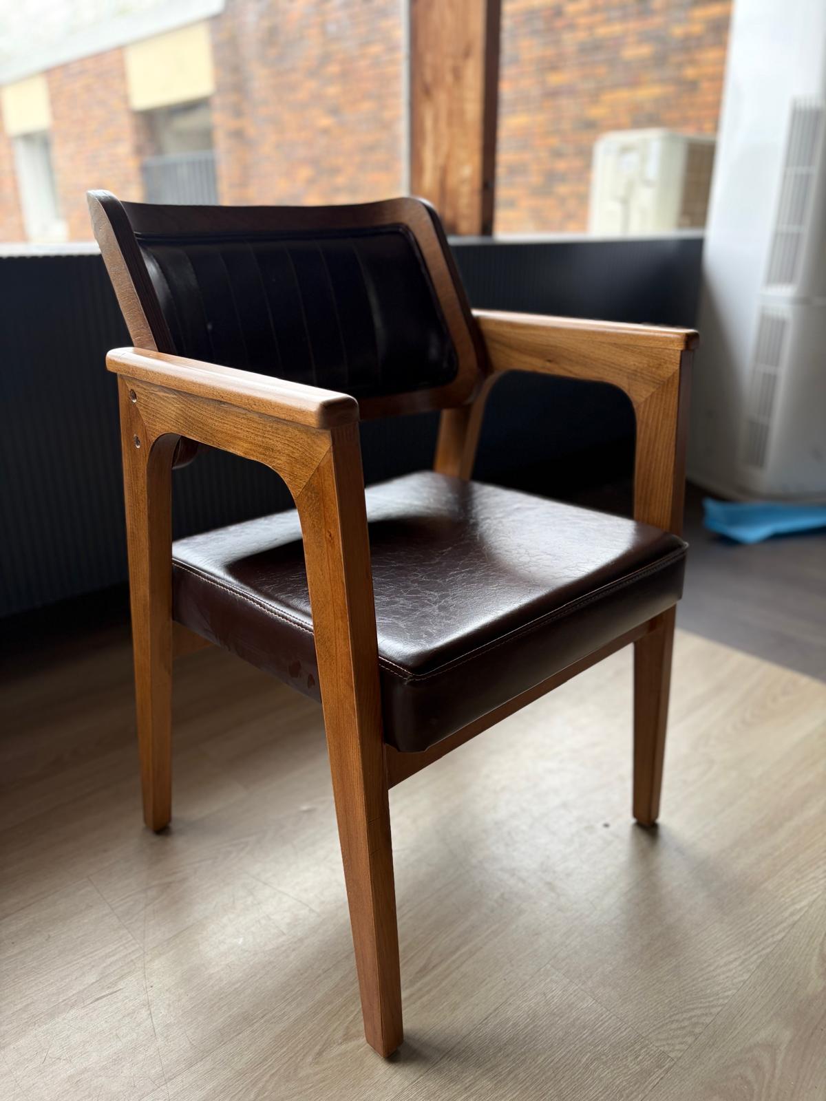 Chaise en bois avec dossier à cadre foncé et assise en simili cuir marron, vue de trois quarts arrière