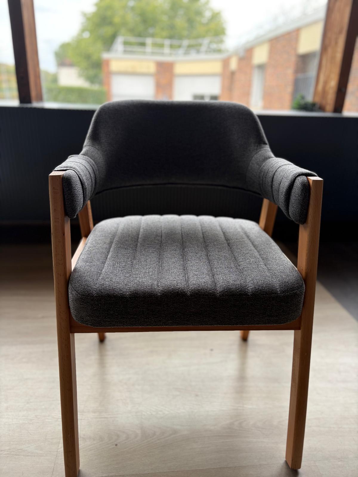 Chaise bois clair avec assise et dossier en tissu gris anthracite, accoudoirs rembourrés, vue de face