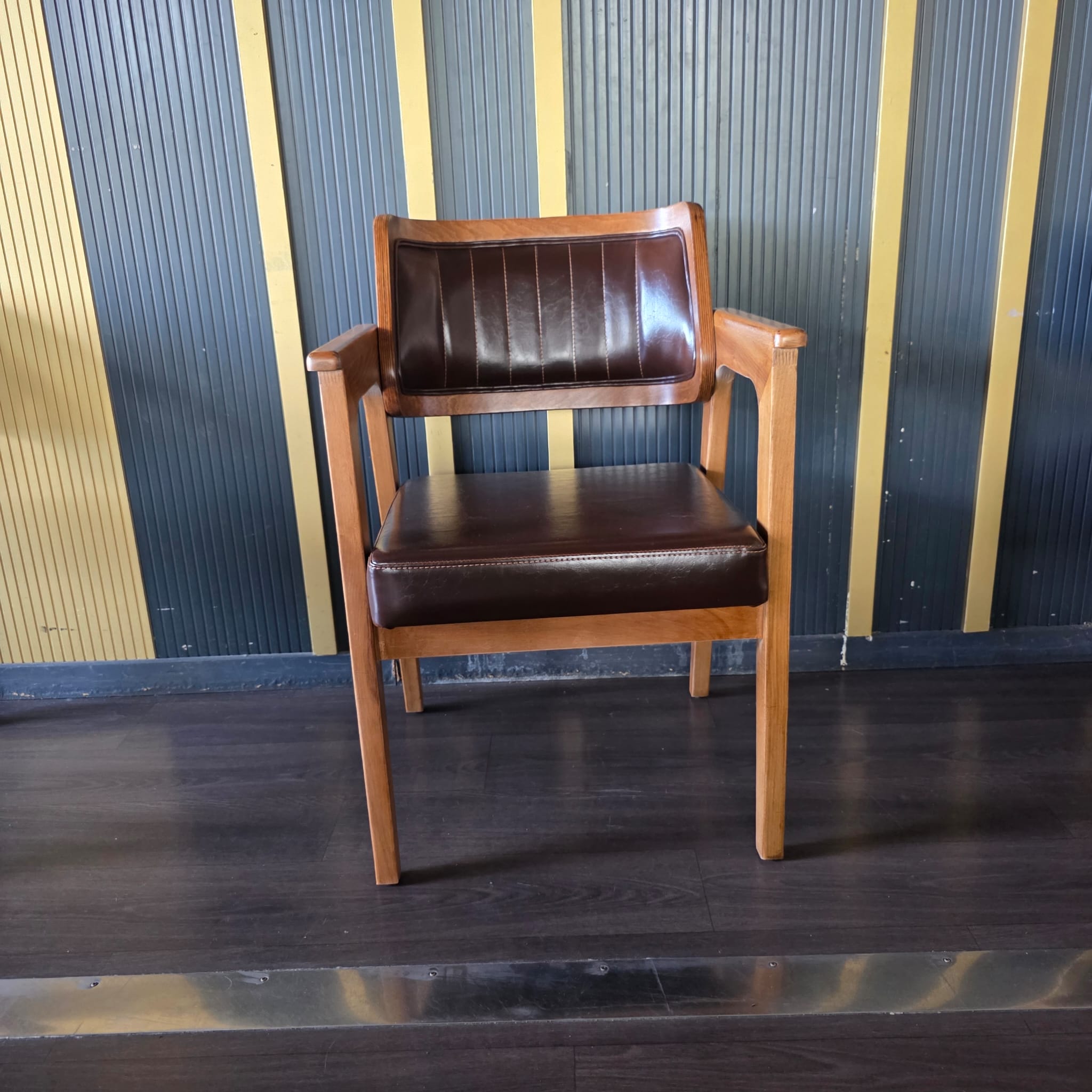 Chaise en bois avec accoudoirs et assise/dossier en simili cuir marron à surpiqûres verticales