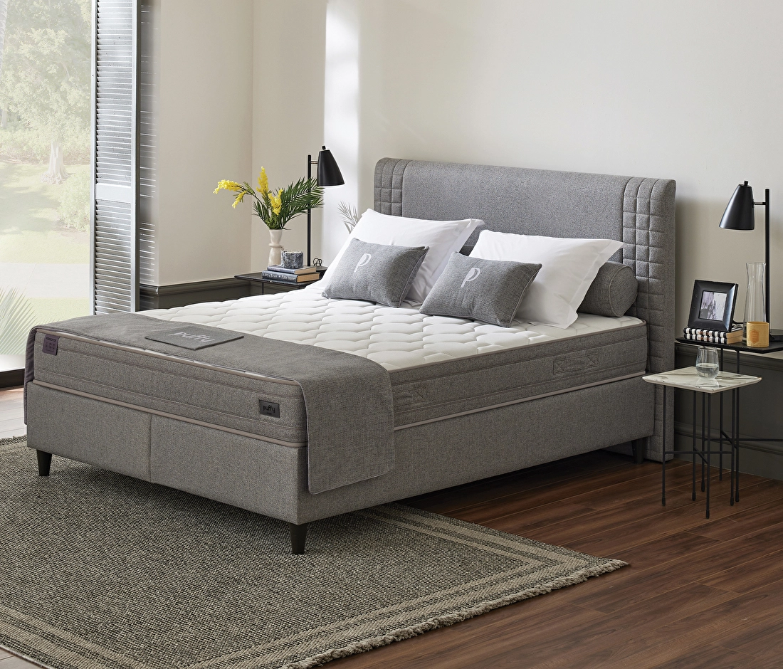 Lit Hydro gris avec matelas Puffy, coussins gris et blancs, chambre avec tables de chevet et lampes noires