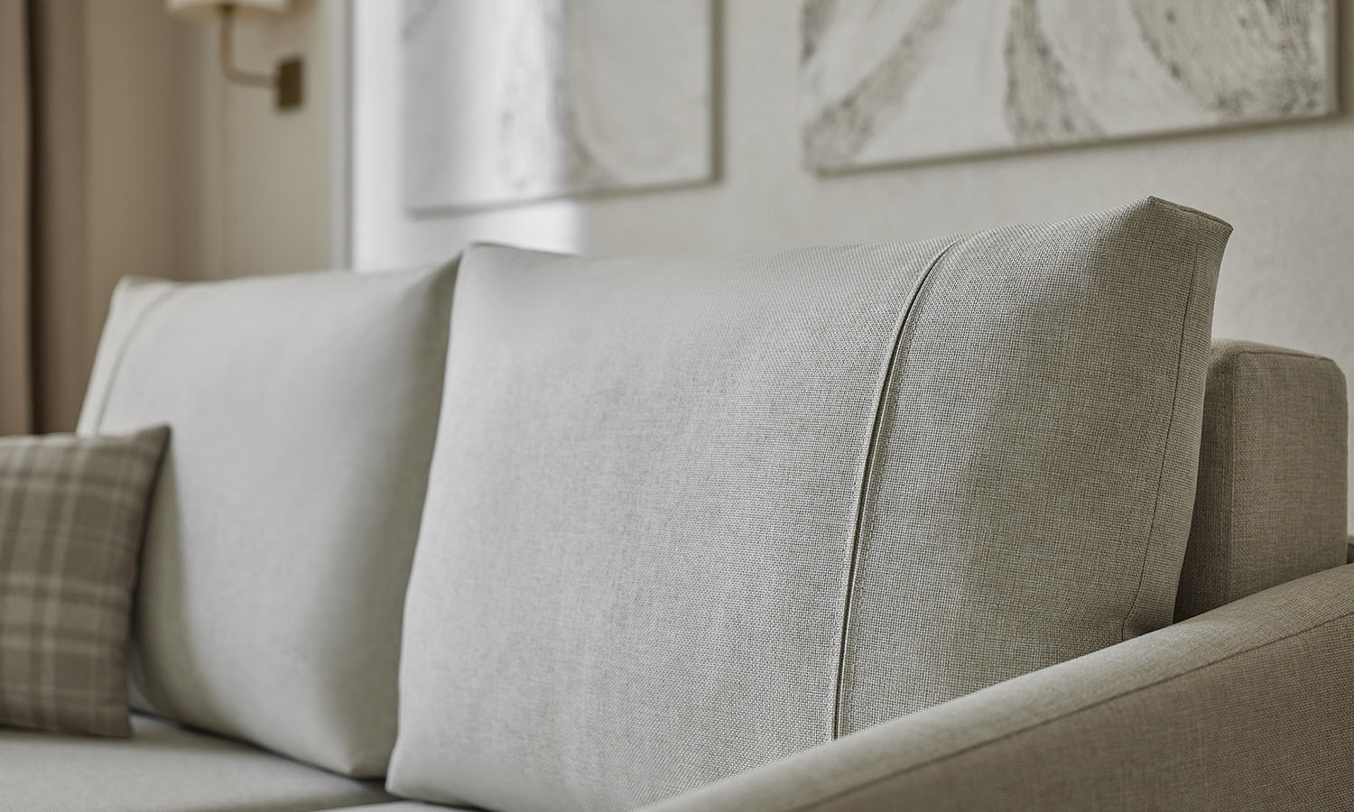 Gros plan sur le dossier et l'assise du canapé Ester, tissu gris clair texturé