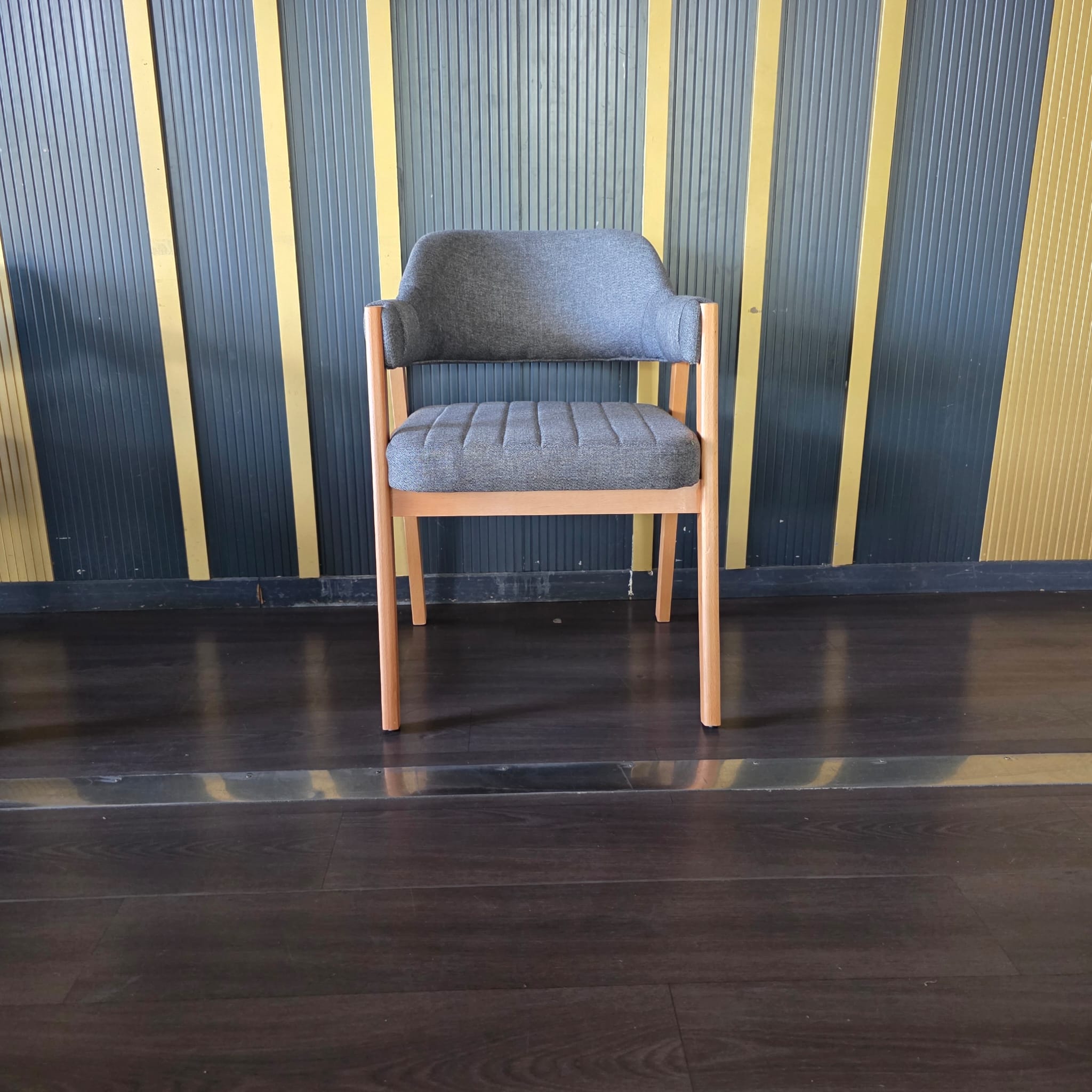 Chaise en bois clair avec accoudoirs et assise/dossier en tissu gris à surpiqûres