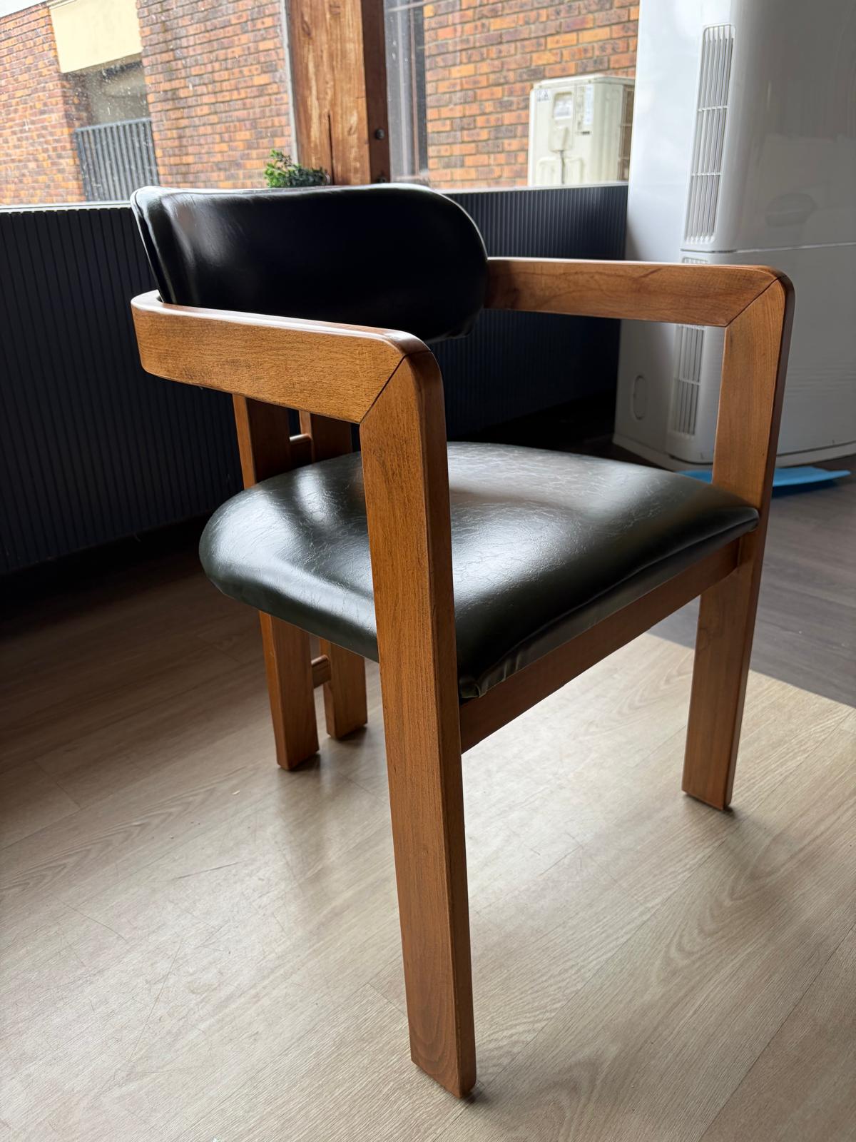 Chaise bois clair avec assise et dossier en simili cuir noir, dossier droit à structure en bois apparente, vue de trois quarts