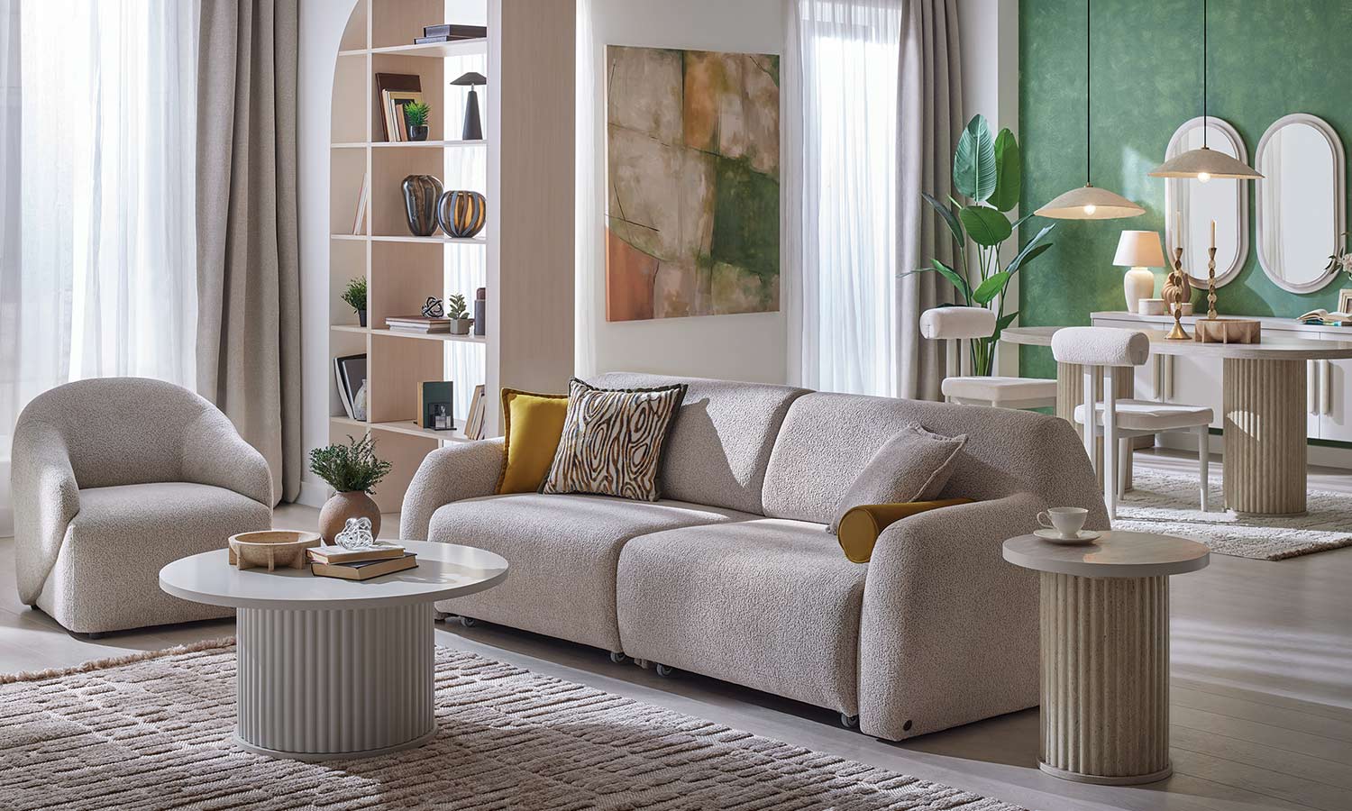 Canapé Latissa beige avec coussins moutarde et imprimé bois, fauteuil ovale assorti, salon avec bibliothèque et coin repas vert