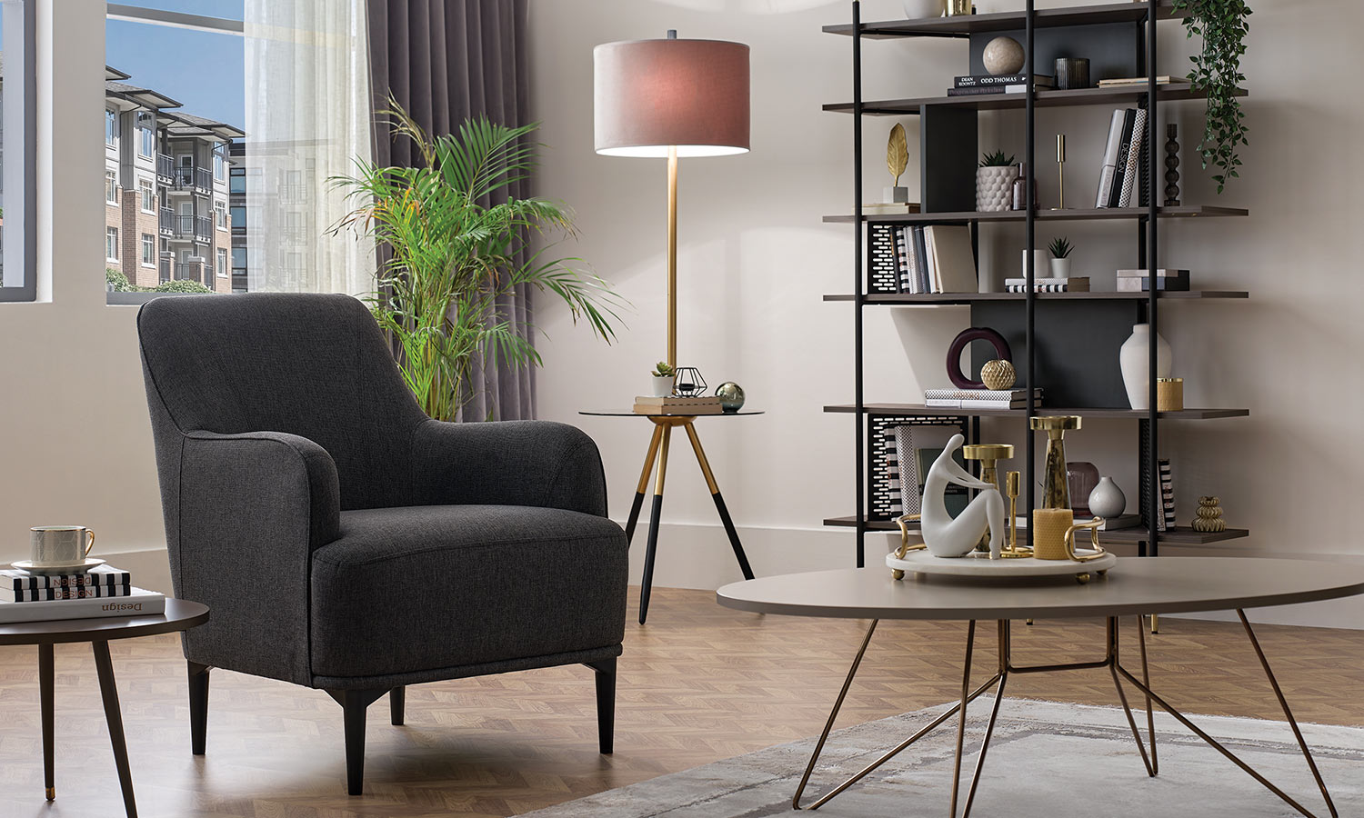 Fauteuil Calis gris anthracite, salon avec bibliothèque en bois et lampadaire à abat-jour bordeaux