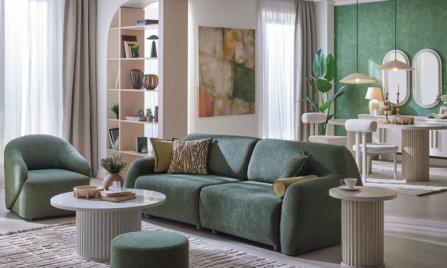 Canapé Latissa vert avec coussins moutarde et imprimé bois, fauteuil ovale assorti, salon avec mur vert et miroirs ovales