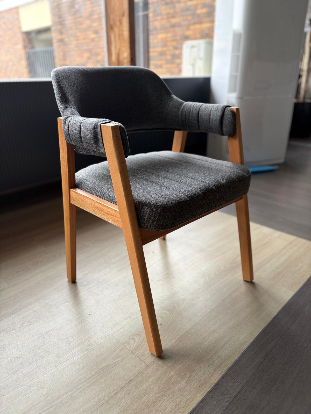 Chaise bois clair avec assise et dossier en tissu gris anthracite, accoudoirs rembourrés, vue de trois quarts