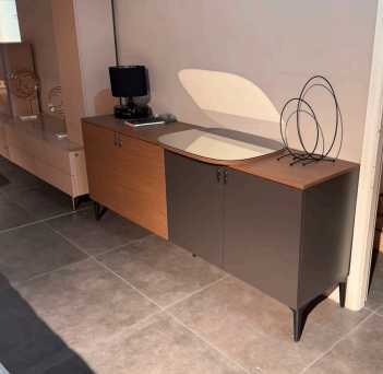 Console Calis bois clair et brun foncé avec pieds fins noirs, en situation avec écran et objets déco